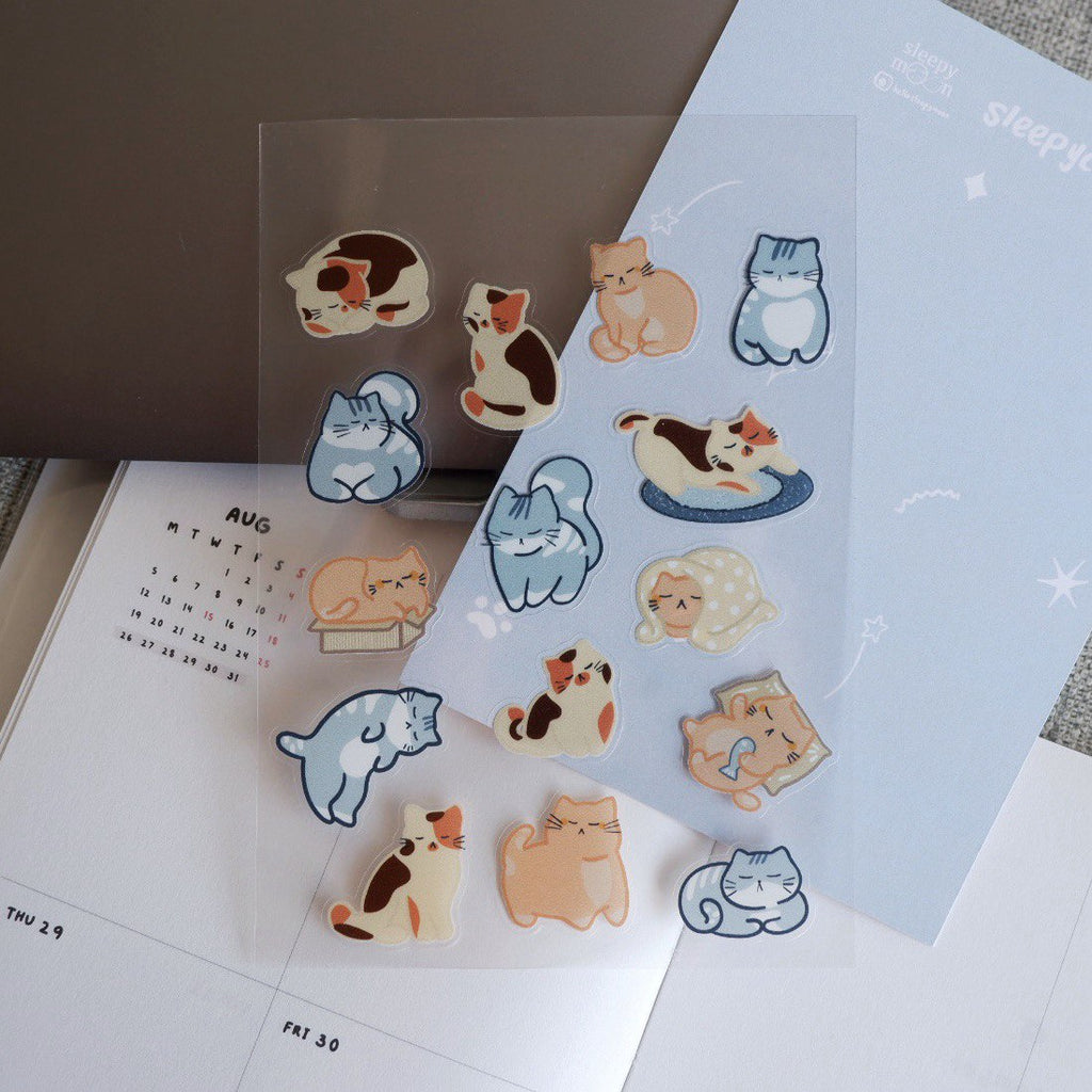 Cat-themed stickers on a planner with a clear sheet