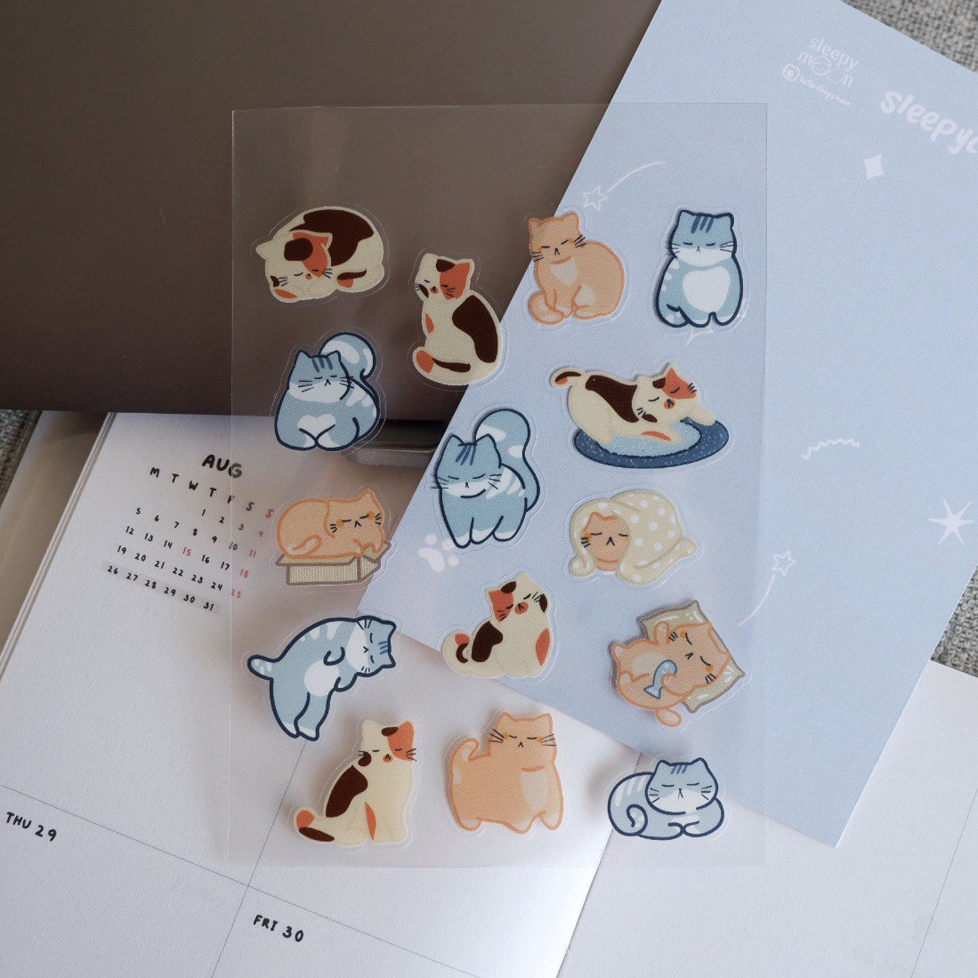 Cat-themed stickers on a planner with a clear sheet